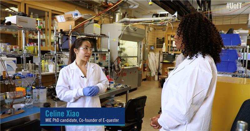 Celine Xiao speaks with Ainka Jess in a lab, both are in white coats.