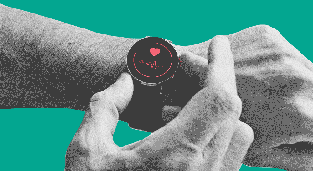 Black and white close up of a wrist wearing a black watch displaying a red heart and waveform.