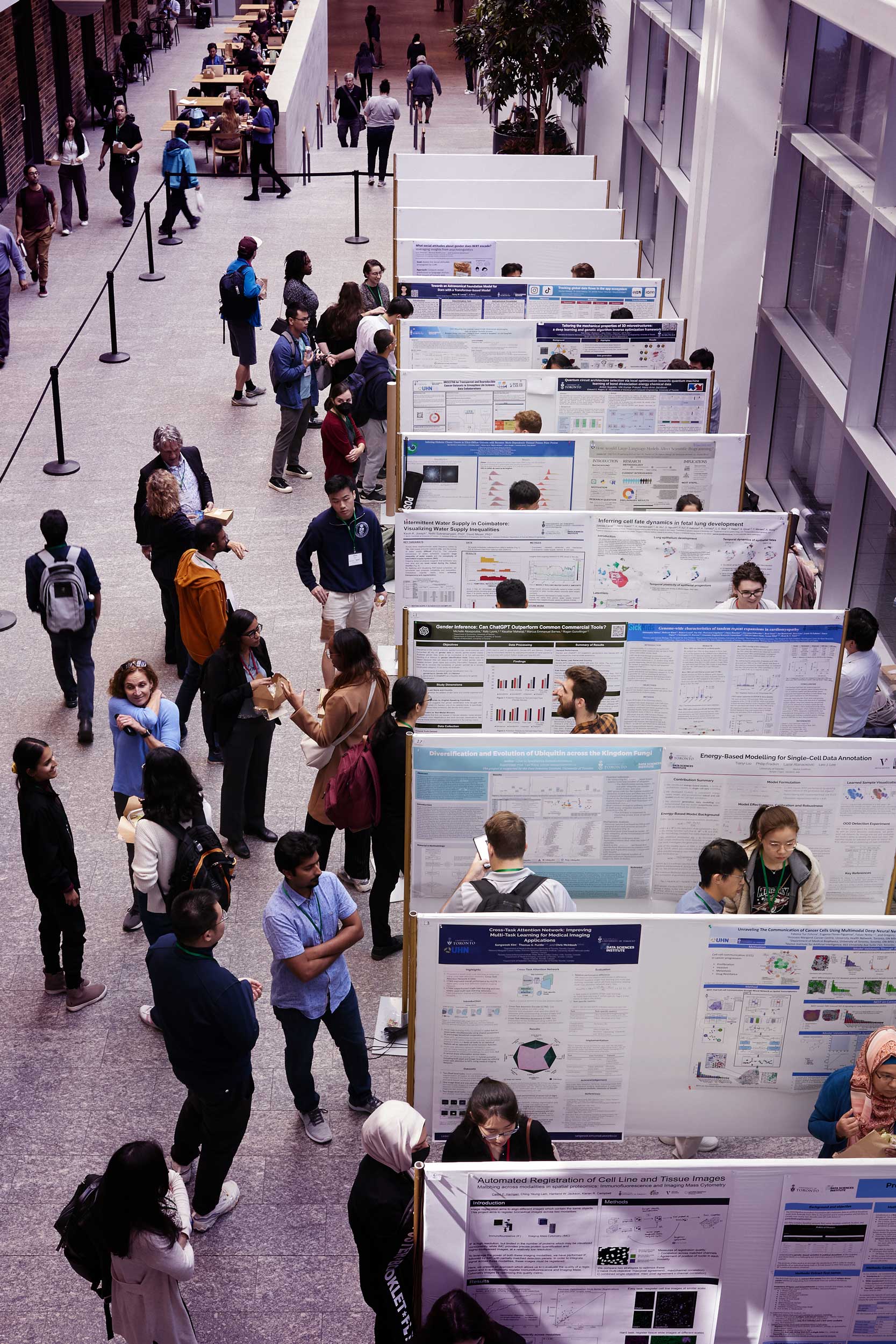 Elevated view of conference attendees taking part in a poster session located in the MaRS building.