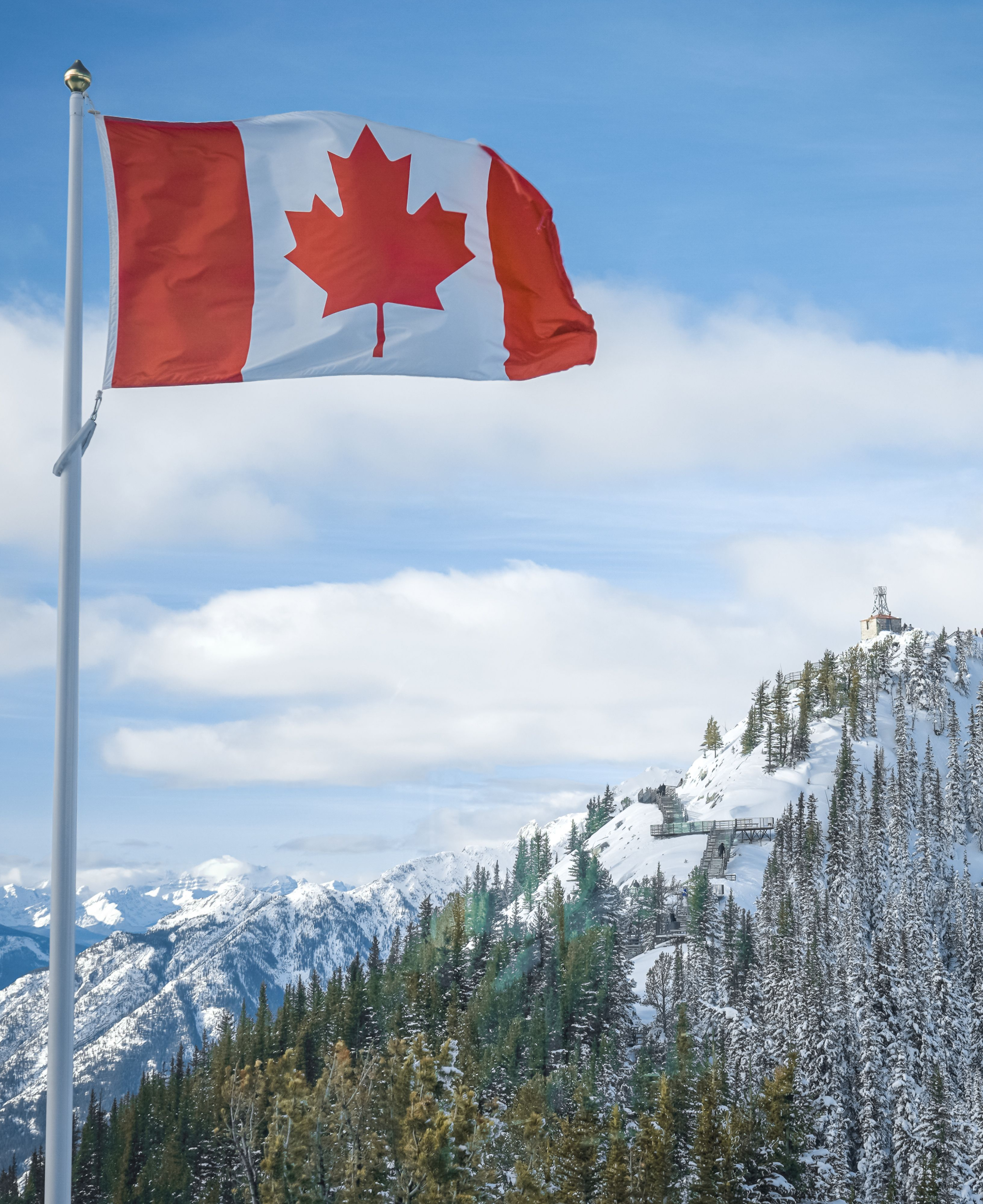 Canadian flag on top of mountain landscape
